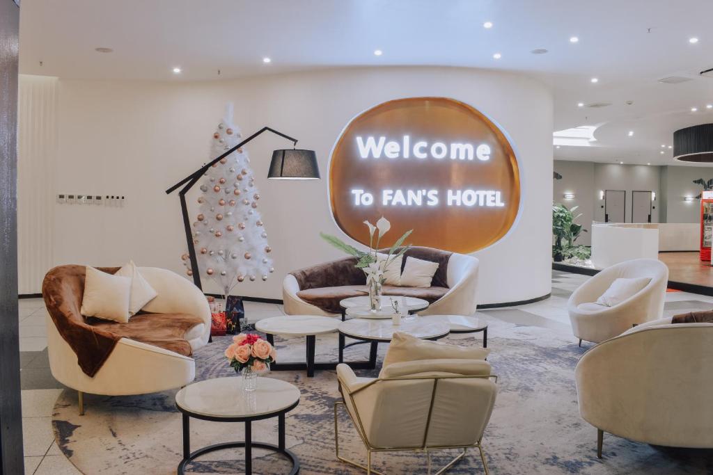 a lobby with couches and chairs and a welcome to farms hotel sign at Fan's Hotel in Baybay