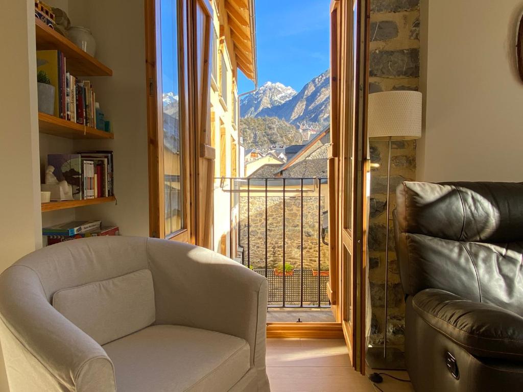 uma sala de estar com uma cadeira e uma grande janela em Apartamento Casa Francho 3 em Panticosa