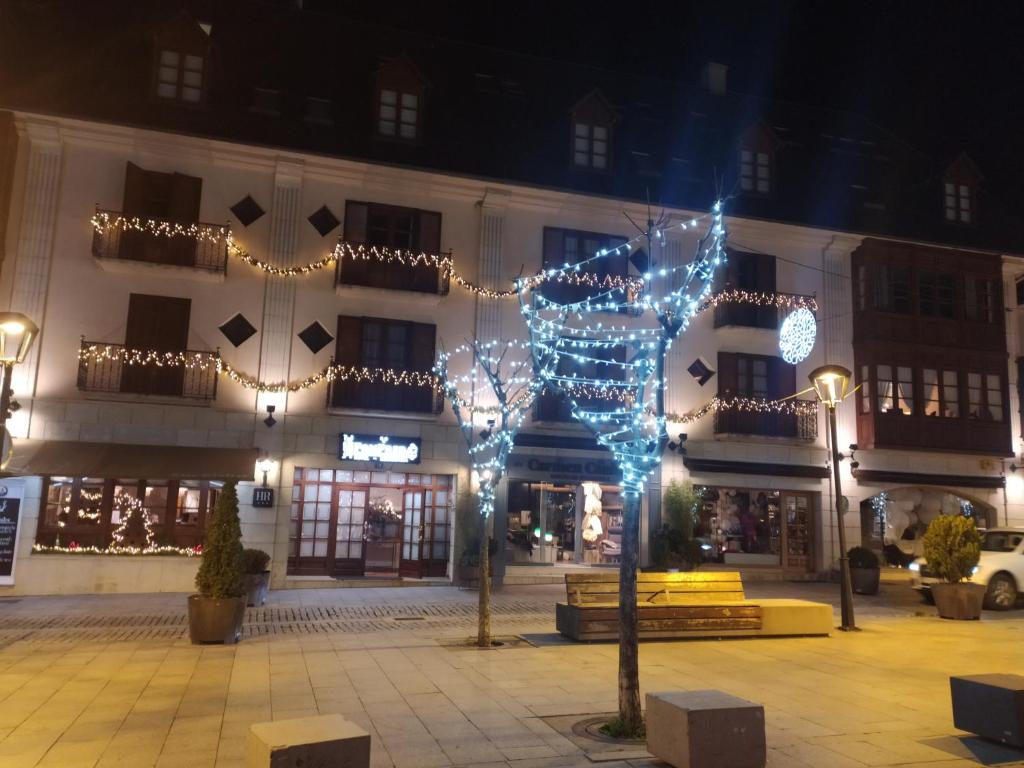 un sapin éclairé devant un bâtiment dans l'établissement Hotel Fonfreda, à Vielha e Mijaran