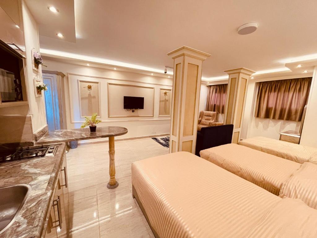 une chambre avec deux lits et une cuisine avec un évier dans l'établissement El mansour hotel apartmen 93, à Mansoura