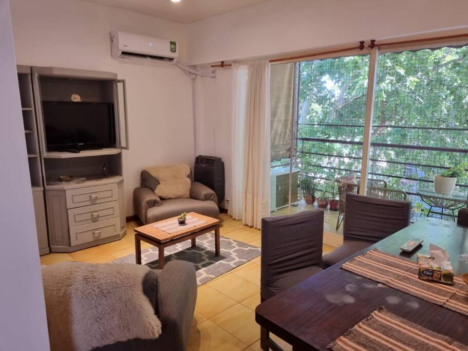 uma sala de estar com uma televisão e uma mesa e cadeiras em Apart Campana VDP em Buenos Aires