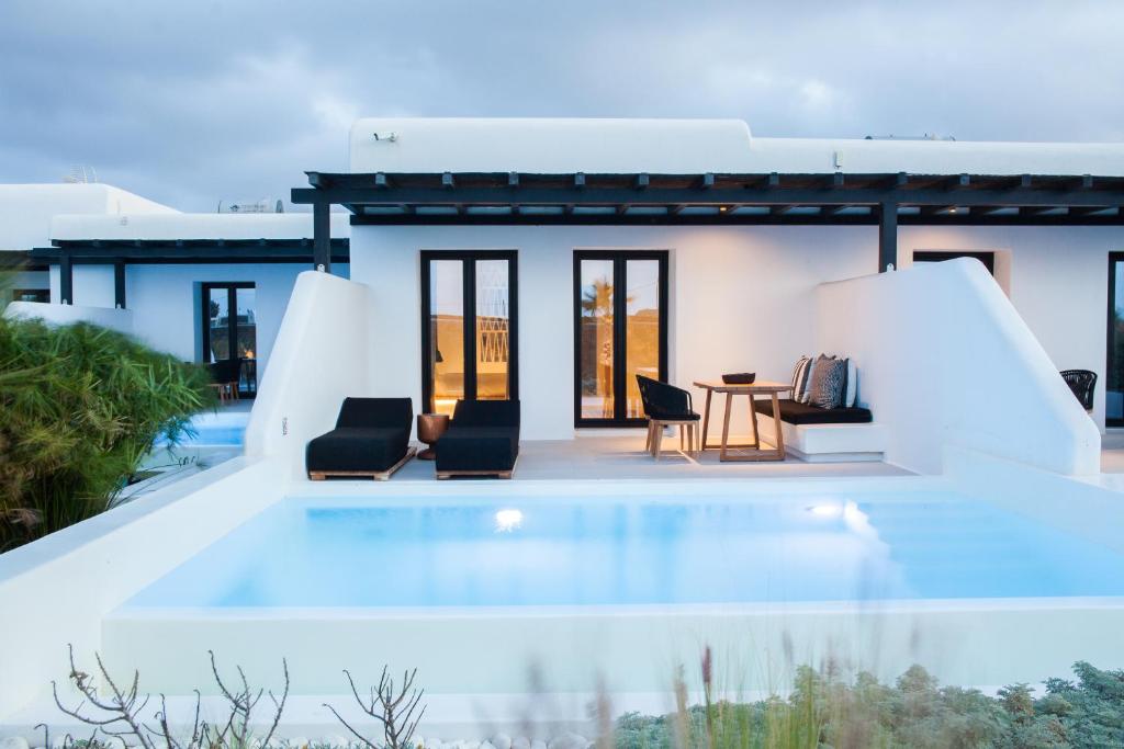 eine Villa mit einem Pool und einem Haus in der Unterkunft Agrari Bo Suites by Mykonos Rocks in Agrari