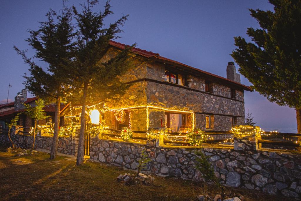 een gebouw met kerstverlichting aan de zijkant bij E L chalet. A cosy mountain retreat. in Palaios Agios Athanasios