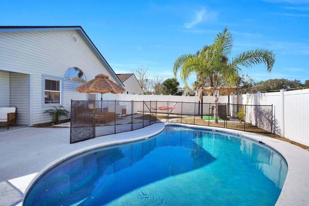 a large blue swimming pool in front of a house at Jax Beach Luxury Oasis W/ Private Pool/Jacuzzi Tub in Jacksonville Beach