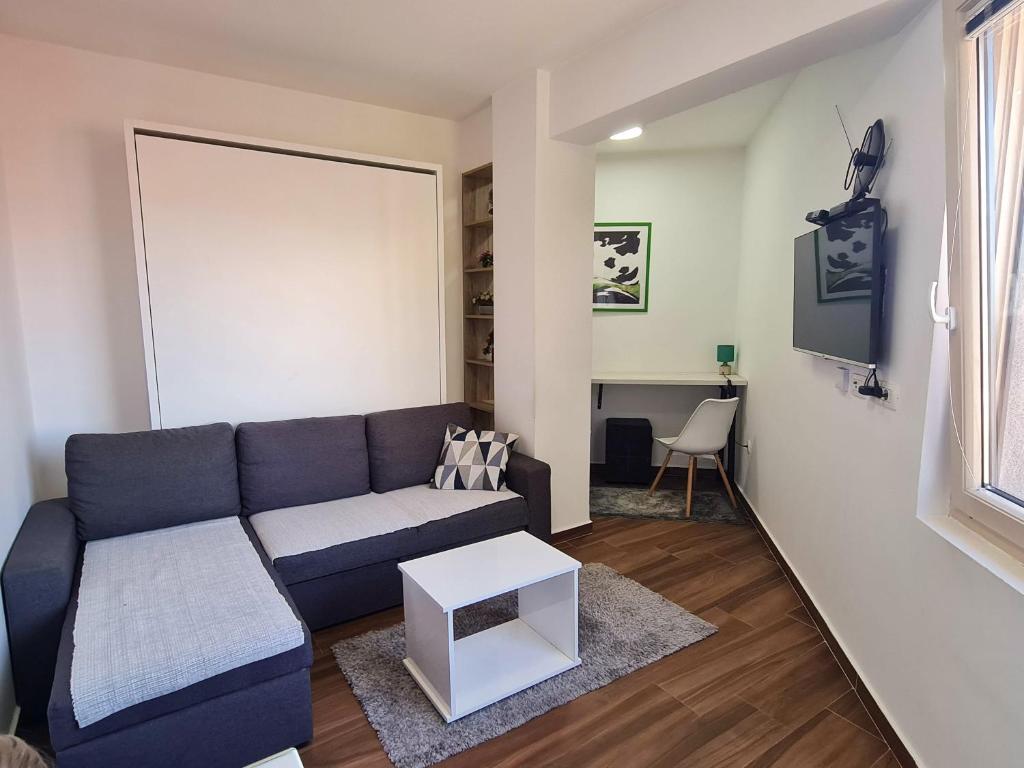 a living room with a blue couch and a table at Victory Apartment in Nikšić