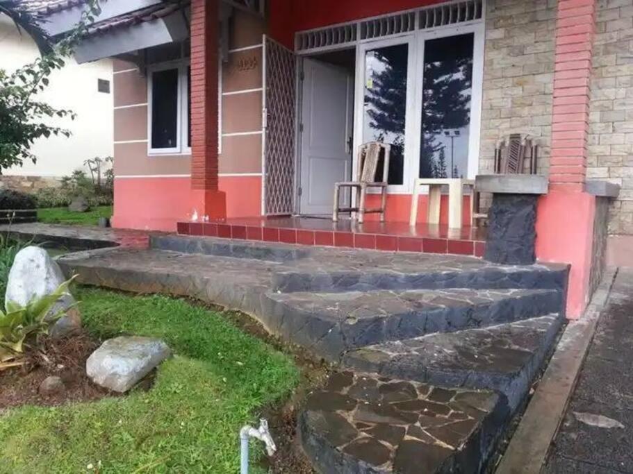 une maison avec des marches menant à la terrasse couverte. dans l'établissement Villa Kota Bunga C - Puncak, à Pacet