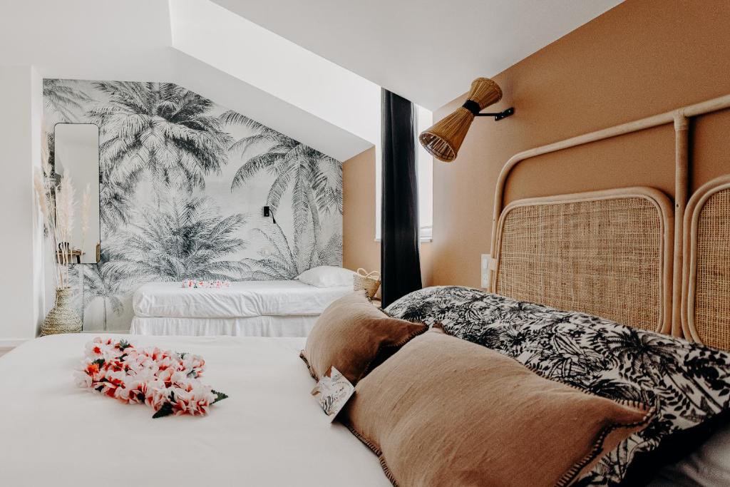 a bedroom with two beds with flowers on it at Hôtel PALMITO in Biarritz