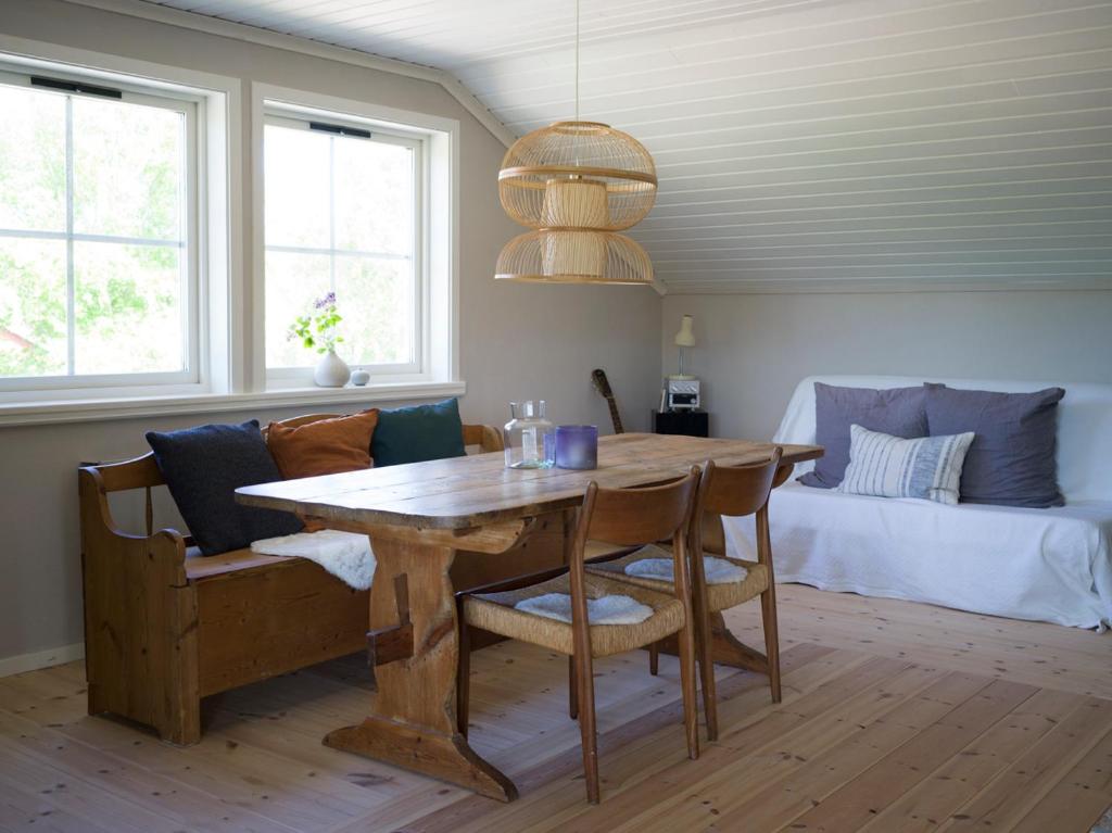 a dining room with a wooden table and chairs at Lovely, bright apartment overlooking nature in Fiskebäckskil