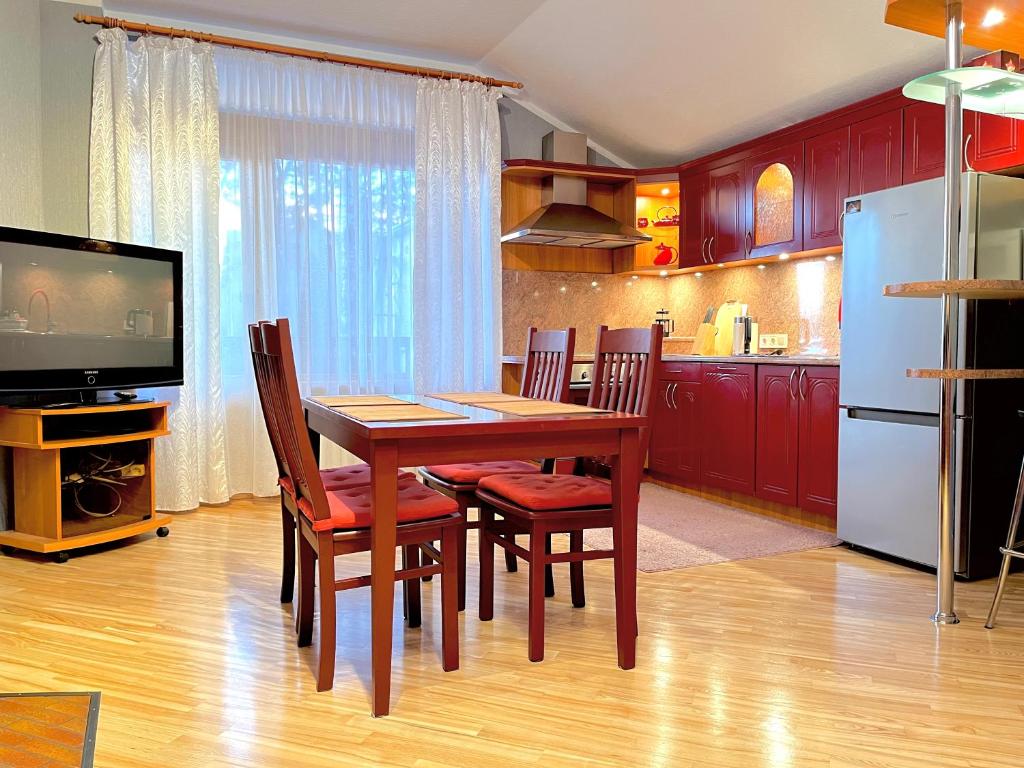 a kitchen with a table and chairs and a television at JAUNA apartments in Jūrmala