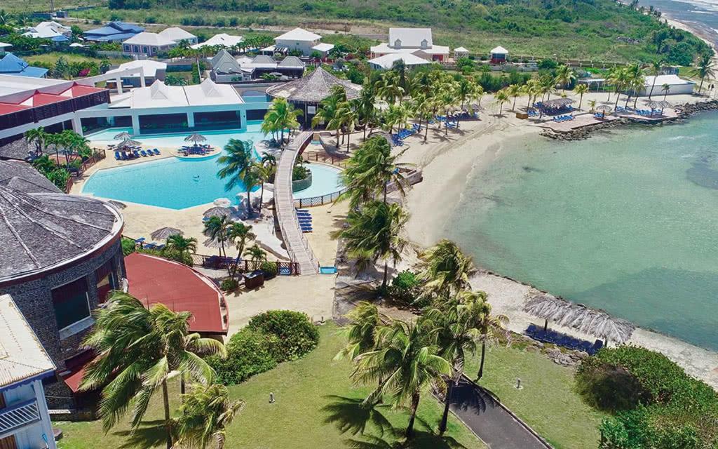uma vista aérea de um resort com uma piscina e uma praia em Romantisme en Bord de Lagon, Piscine surveillée par un maitre nageur & Plage em Saint-François