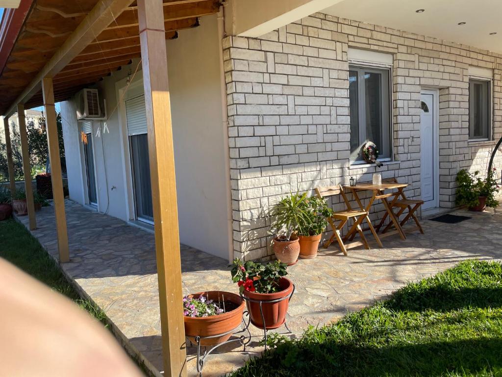 a patio with a table and potted plants on it at Nice Cosy apartment in Igoumenitsa in Igoumenitsa