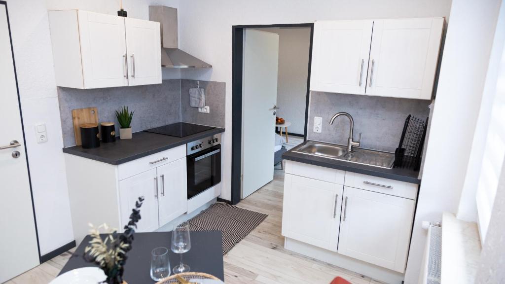 a kitchen with white cabinets and a sink at Entdecke das idyllische Allgäu - Verbringe deinen Traumurlaub in unserer gemütlichen Ferienwohnung in Immenstadt im Allgäu