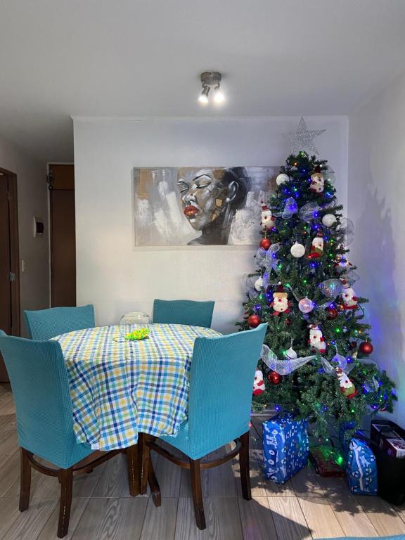 una sala da pranzo con albero di Natale e tavolo e sedie di Central departamento en recinto privado Aire acondicionado Wifi Estacionamiento a Rancagua