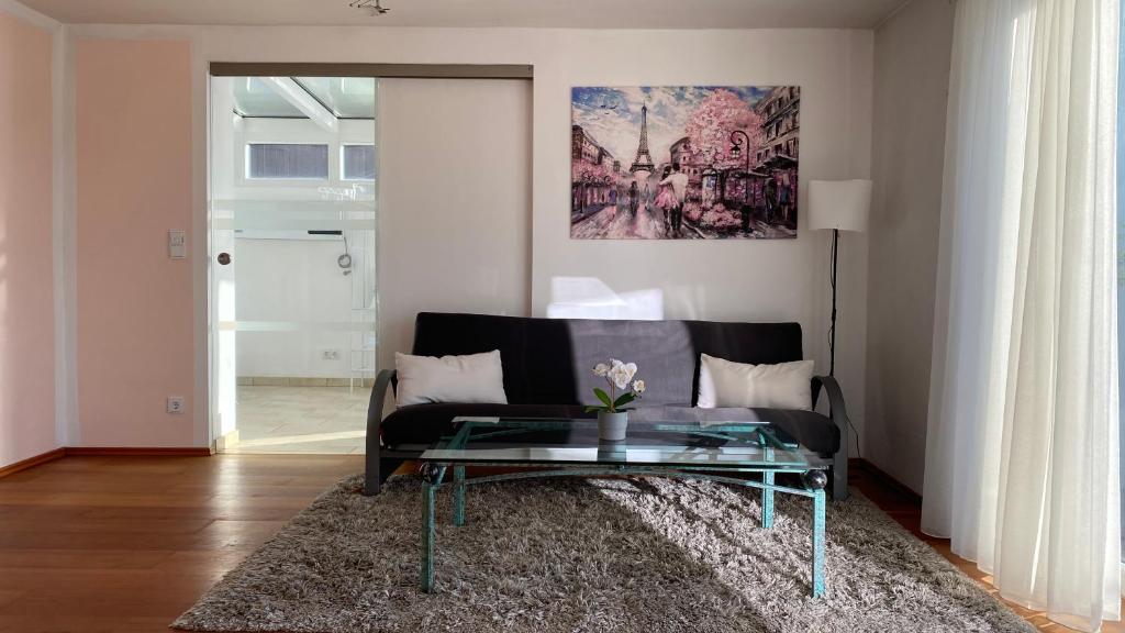 uma sala de estar com um sofá e uma mesa de vidro em FeWo Luxus Wohnung im eigenen Ferienhaus, 120 qm, Nähe Regensburg mit Balkon, Terrasse & Garten, gute Zuganbindung em Laaber
