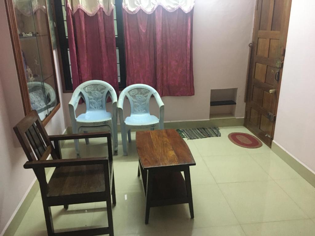 a room with chairs and a table and a table and chairs at Omkara Homestay in Puttūr