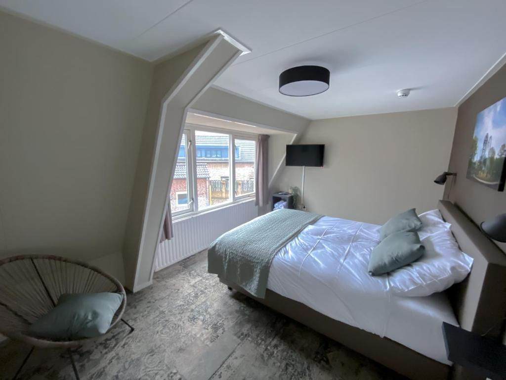 a bedroom with a bed and a window at Hotel de Slapende Hollander in Kaatsheuvel