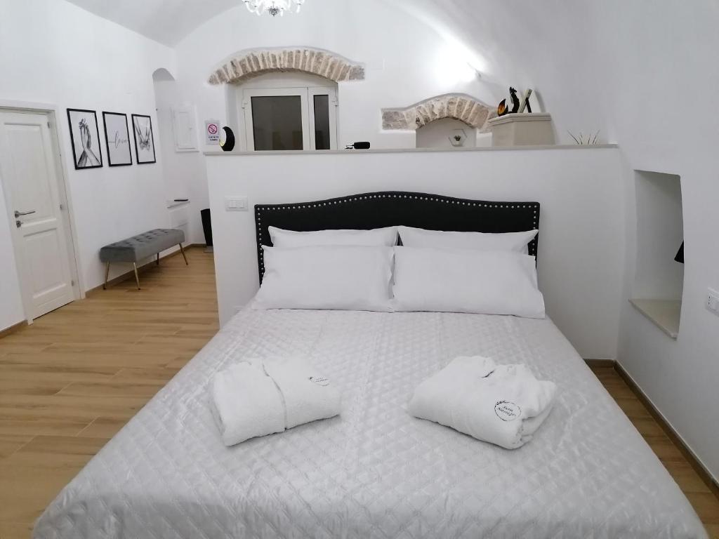 Una cama blanca con dos almohadas blancas. en Appartamenti Mascagni en Sannicandro di Bari