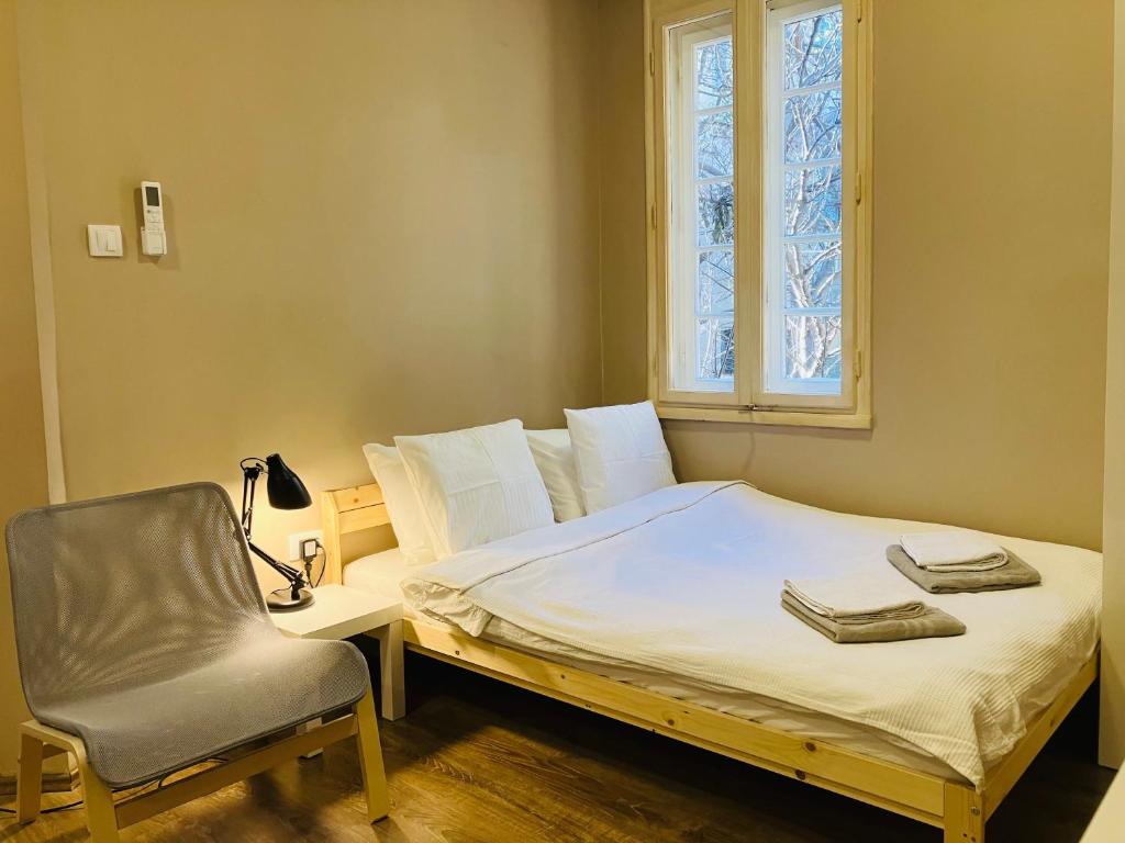 SajmišteにあるSalon Studio Savamalaのベッドルーム1室(ベッド1台、椅子、窓付)