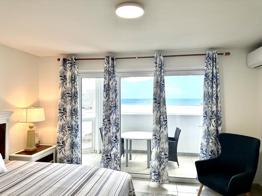 um quarto com uma cama e vista para o oceano em Pirates Booty Beach Bar Studio next to The Morgan Resort em Maho Reef