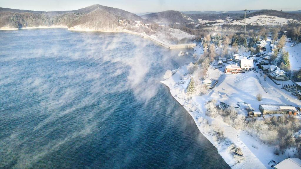 an aerial view of a beach with snow and water at Sztygarka Hetmańska Resort Solina in Solina