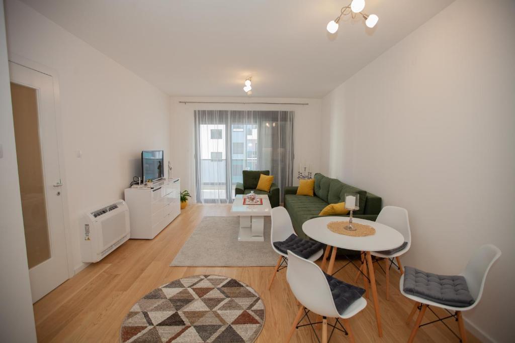 a living room with a green couch and a table at Apartman Kuburica in Trebinje