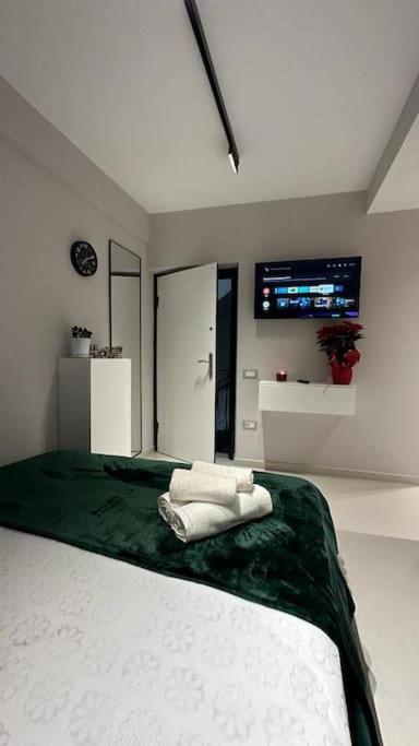 um quarto com uma cama com lençóis verdes e brancos em Host Apartament Elio em Tirana