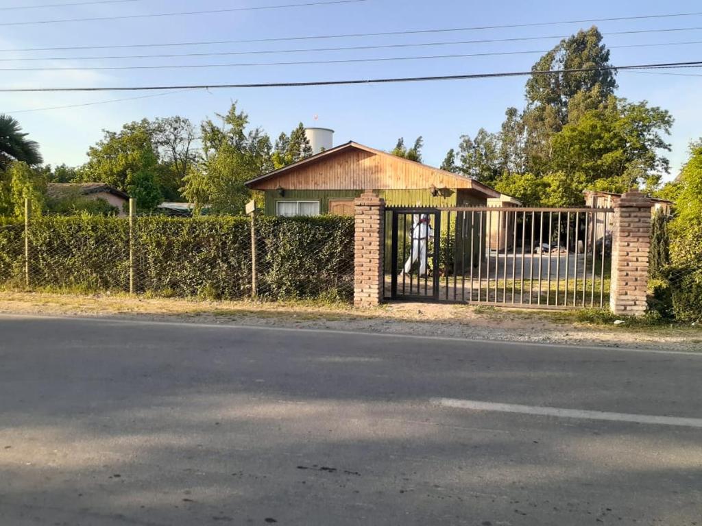 einen Zaun vor einem Haus mit einem Tor in der Unterkunft Cabañas Anny in Linares