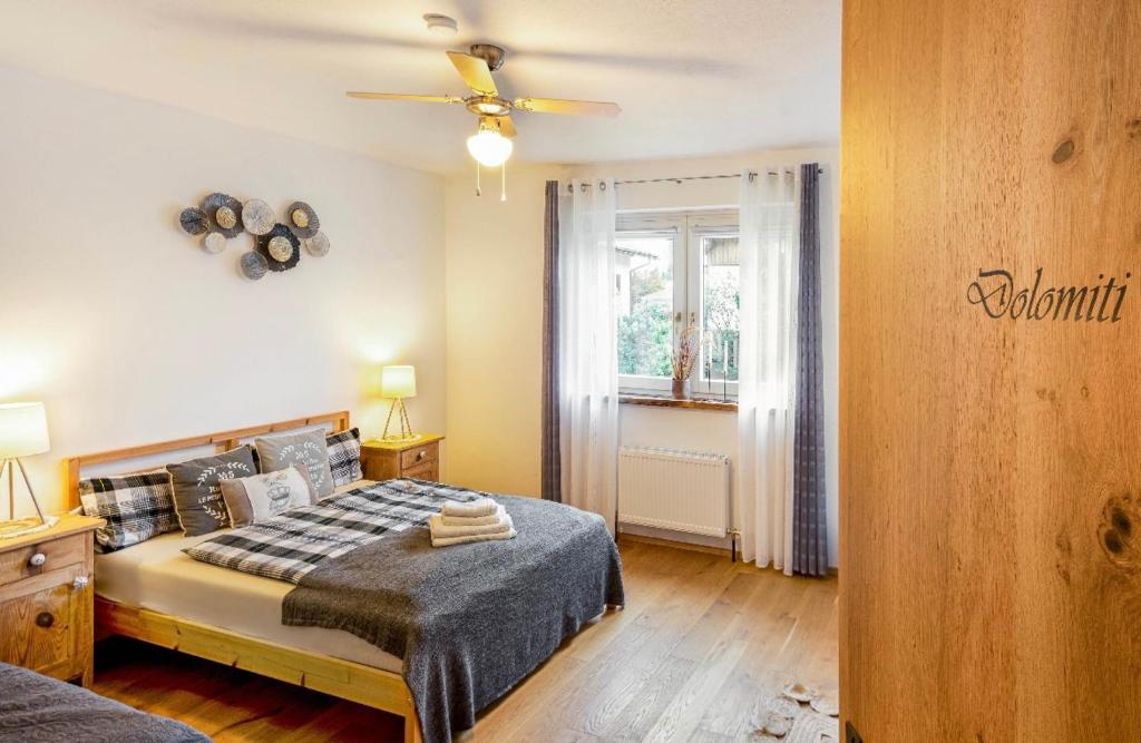 a bedroom with a bed and a ceiling fan at The Dolomiti View in Debant