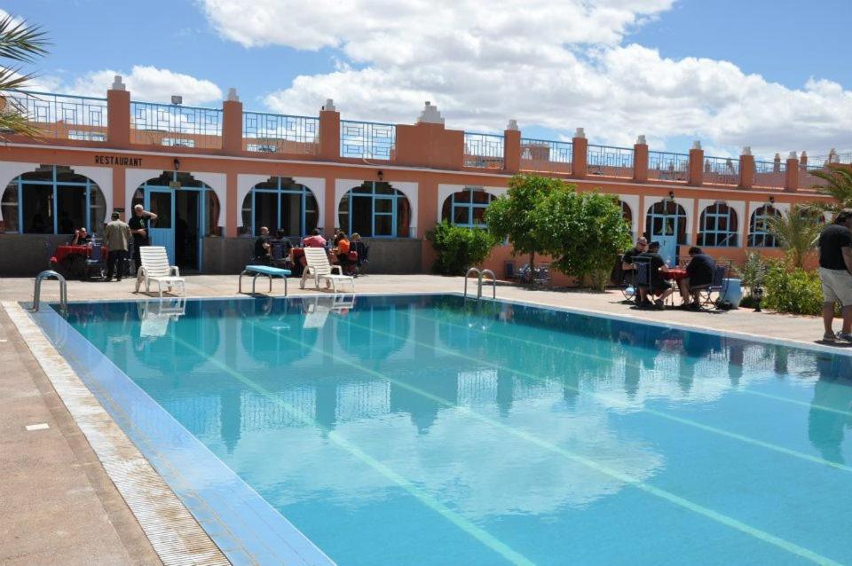 a large blue swimming pool in front of a building at HOTEL BOUGAFER - TAZARINE in Tazzarine