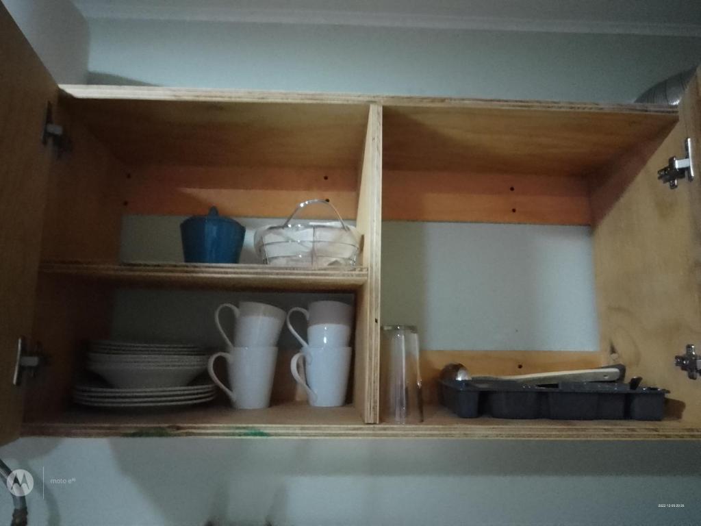 a cabinet with plates and cups and dishes on it at Apartamento por dia in Puerto Montt