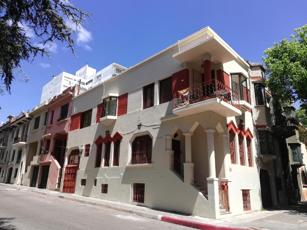 a white building with red windows on a street at Private Room in Beautiful Home in Montevideo