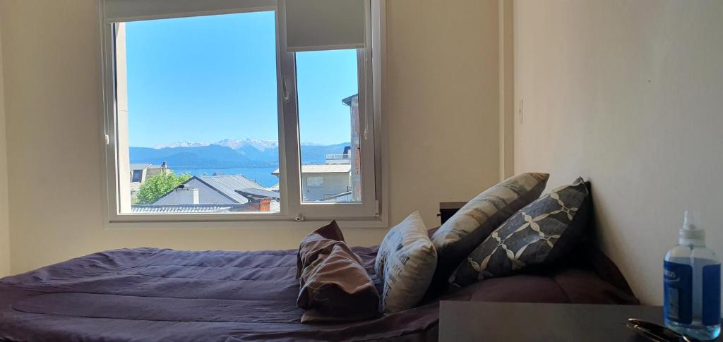 1 dormitorio con cama y ventana grande en Mono Villegas 1 en San Carlos de Bariloche