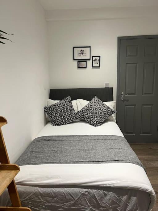 1 dormitorio con cama con almohadas y puerta en 1 Bedroom flat in Euston! 4 person. en Londres