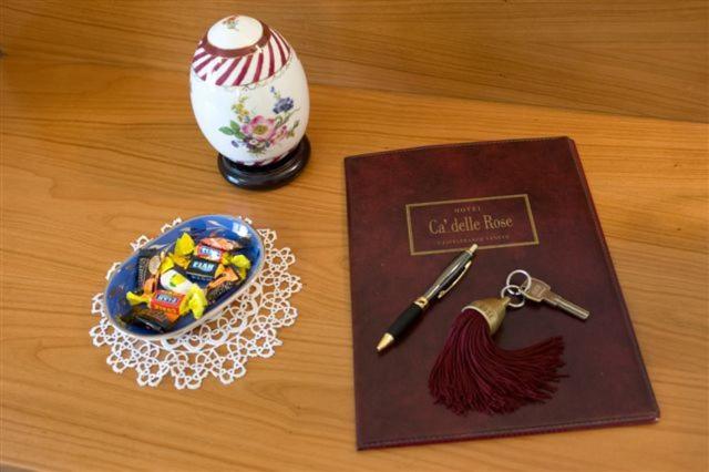 a wooden table with a book and a plate of candy boxes at Ca' delle Rose in Castelfranco Veneto