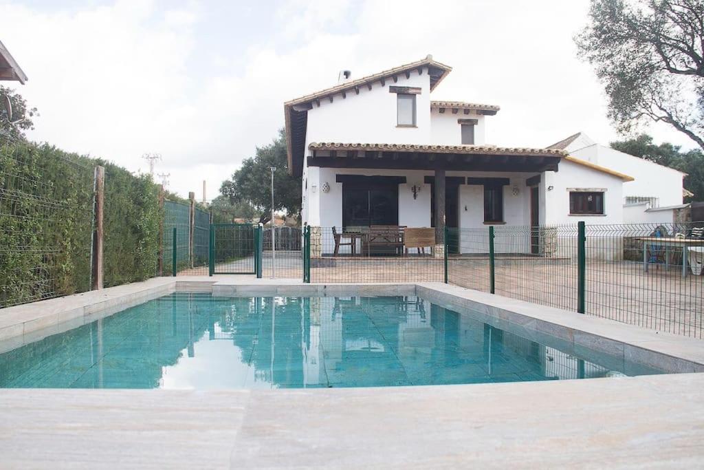 a house with a swimming pool in front of a house at CASA HUGANA in Benalup Casas Viejas