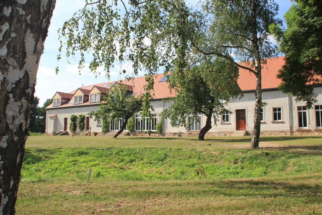 ein großes weißes Haus mit rotem Dach in der Unterkunft Gutshof Sagritz in Golßen