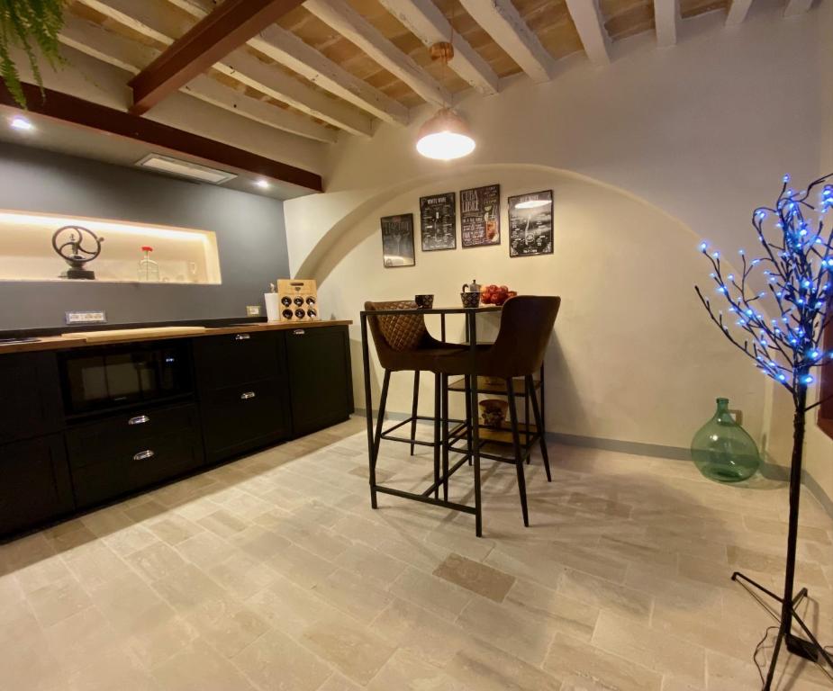 a kitchen with a counter and a stool in a room at Vermaaten Boutique Suites Diamond in Todi