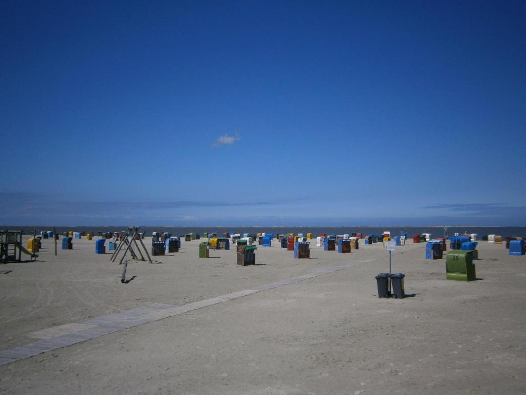 una playa con muchos cubos de basura en la arena en Strandnahes-Ferienhaus-Nessmersiel, en Nessmersiel