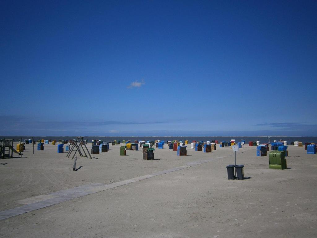 ネスマージールにあるStrandnahes-Ferienhaus-Nessmersielの砂のゴミ箱がたくさんある浜