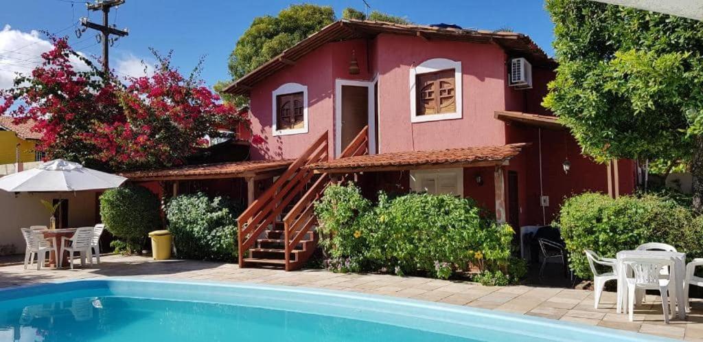 a house with a swimming pool in front of a house at Chalé Beija Flor in Praia do Frances