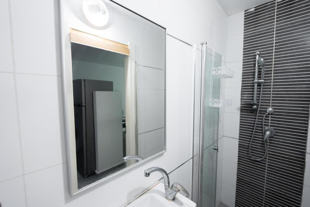 ein Bad mit einem Waschbecken und einem Spiegel in der Unterkunft Luxury studio 5 min from beach in Rischon LeZion