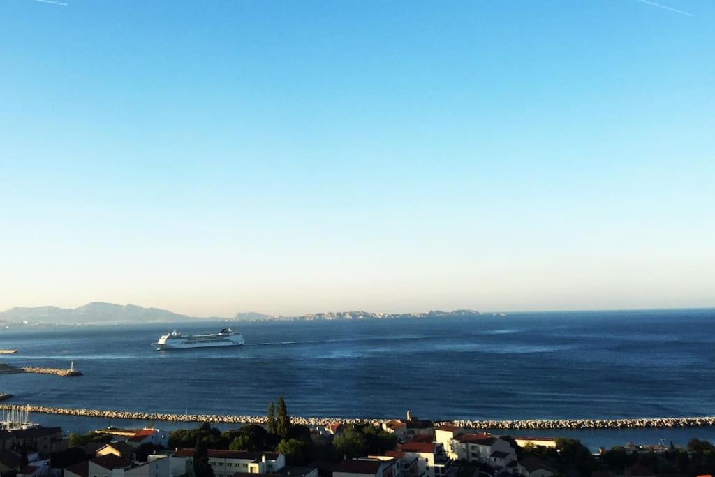 un grand bateau dans l'eau près d'une ville dans l'établissement Superbe terrasse avec vue panoramique sur la mer, à Marseille