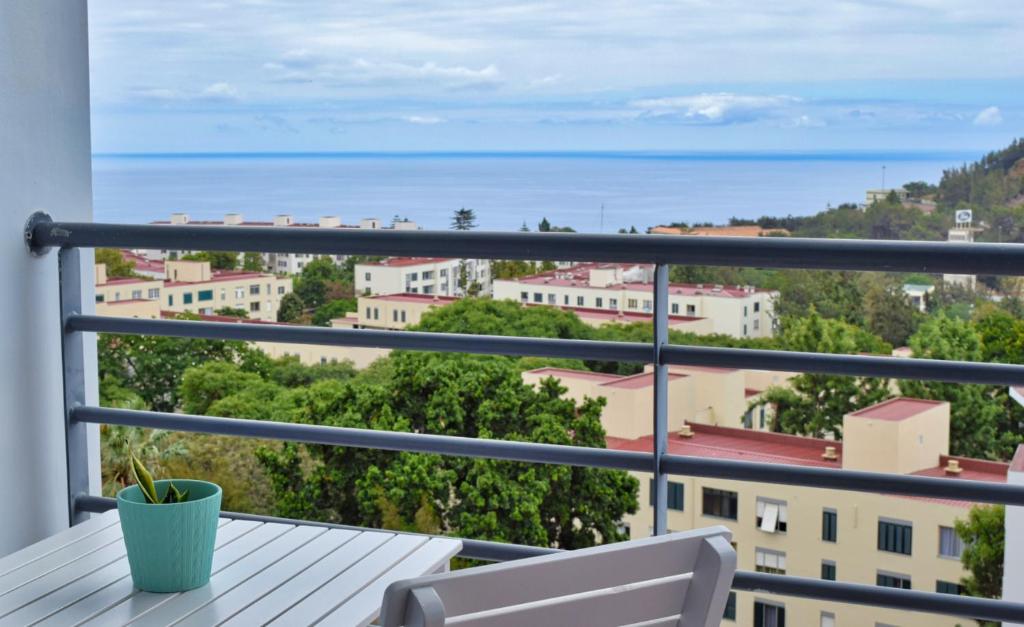 豐沙爾的住宿－Sao Martinho, a Home in Madeira，阳台配有桌子,享有海景。