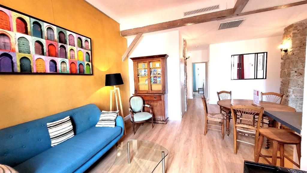 a living room with a blue couch and a table at ZePerfectPlace - Vieux Nice Garibaldi 3 chambres in Nice