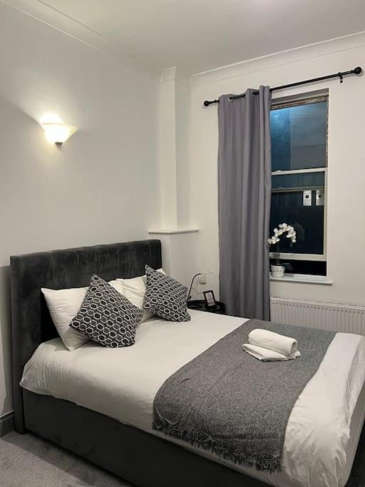 a bedroom with a bed with pillows and a window at 1 bedroom flat in Kings cross! London in London