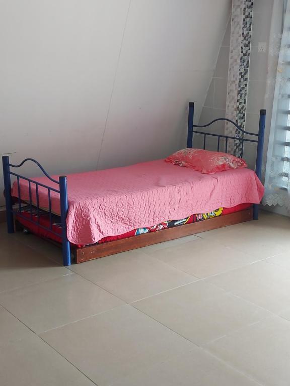 a bed with a red comforter on it in a room at Panorama Homestay in Jeram