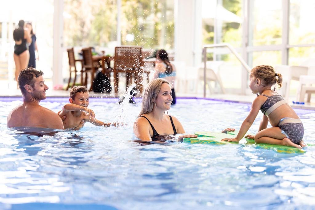 eine Gruppe von Personen in einem Schwimmbad in der Unterkunft Commodore Airport Hotel Christchurch in Christchurch