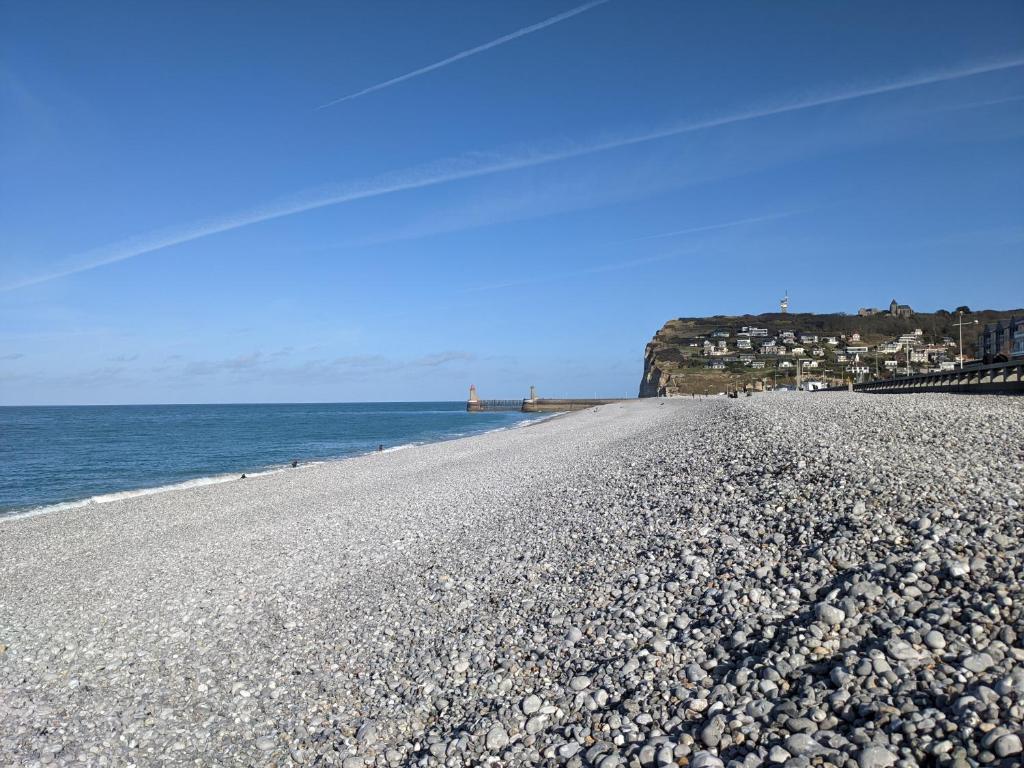 a rocky beach with the ocean in the background at Les Gîtes Panorama et Perle Vue Mer in Fécamp