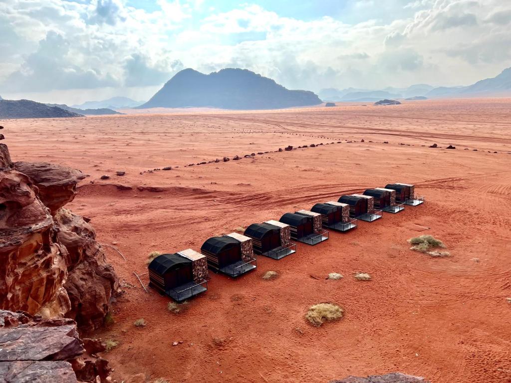 Una fila de camiones estacionados en el desierto en Wadi Rum Shooting Stars Camp, en Wadi Rum