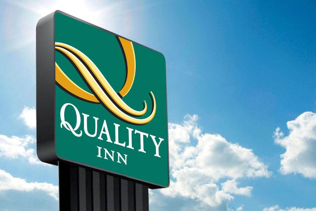 a sign for a quality inn with a cloudy sky in the background at Quality Inn Victorville I-15 in Victorville
